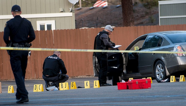 Police investigate the scene where pastor Tim Remington was shot six times as he was leaving the Altar Church in Coeur d'Alene. (Kathy Plonka/The Spokesman-Review, via AP)