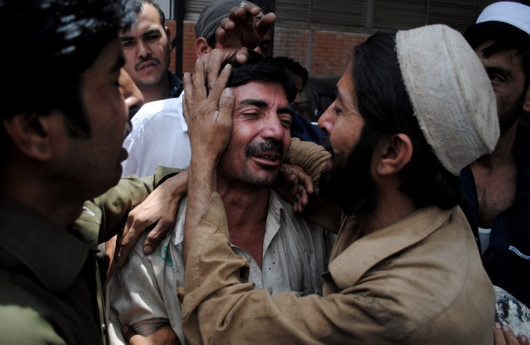 People comfort a family member of a female polio worker who was killed by unknown gunmen, at a local hospital in Peshawar, Pakistan, Tuesday, May 28, 2013. Police say gunmen in Pakistan have shot dead a female polio worker and wounded another in the northwest, police said. (AP Photo/Mohammad Sajjad)