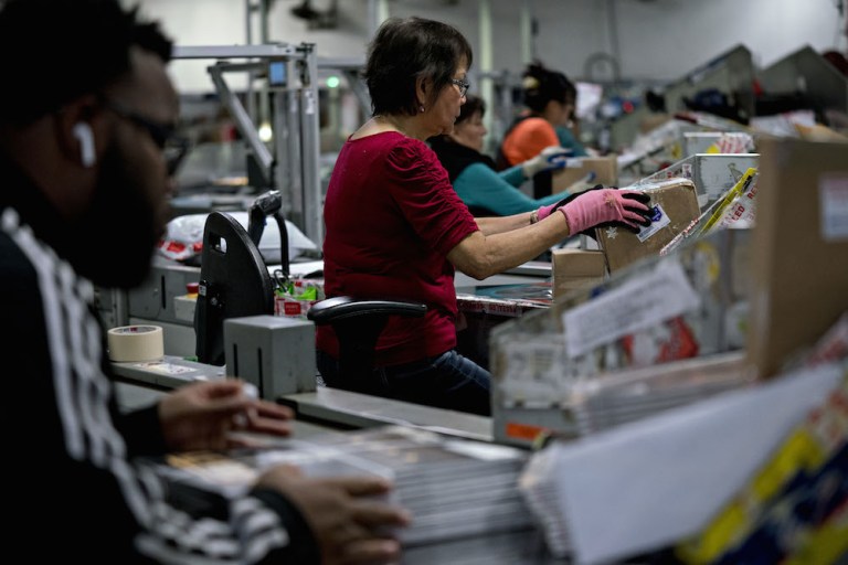 Workers sort packages at the United States Postal Service (USPS) Merrifield processing and distribution center in Merrifield, Virginia, U.S., on Wednesday, Dec. 19, 2018.