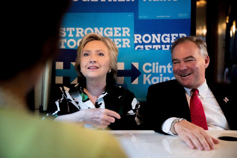 Democratic presidential candidate Hillary Clinton, Democratic vice presidential candidate Sen. Tim Kaine, D-Va., speak together on their campaign bus after visiting Imani Temple Ministries in Cleveland, Sunday, July 31, 2016. (AP Photo/Andrew Harnik)