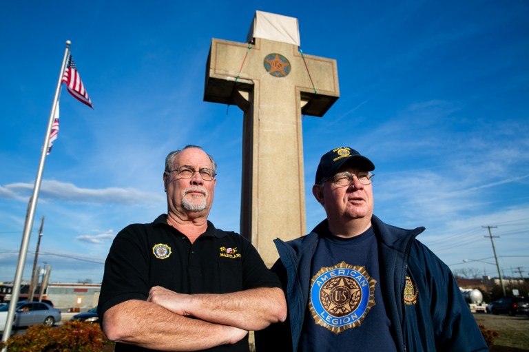 Philip Holdcraft, left, past commander of Colmar Manor American Legion Post 311, and Mike Moore, right, past commander of the Greenbelt American Legion Post 136. This week, the Supreme Court will hear arguments over the meaning of the Bladensburg World War I Veterans Memorial (otherwise known as the Peace Cross) in the The American Legion v. American Humanist Association case. The Peace Cross memorial, located in the three-way junction of Bladensburg Road, Baltimore Avenue, and Annapolis Road in Bladensburg, Maryland, Monday, February 25, 2019.  The U.S. Supreme Court has agreed to hear a case about whether the nearly 100-year-old, cross-shaped war memorial violates the Constitution's required separation of church and state.