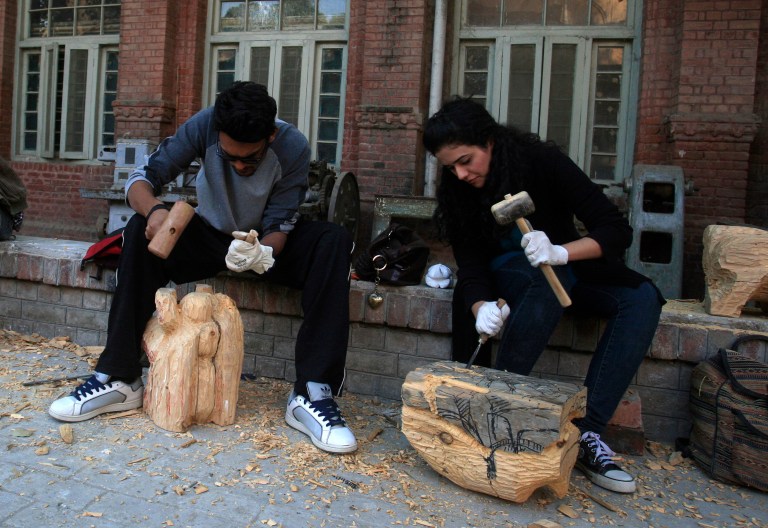   In this photo taken on Tuesday, Dec. 6, 2012, Pakistani students carve wooden statues in the National College of Arts in Lahore, Pakistan. A series of provocative paintings of Muslim clerics in scenes suggesting homosexuality has sparked a moral and legal crisis at Pakistanâs leading arts college after extremists threatened violence, declaring that the works insult Islam.(AP Photo/K.M. Chaudary)  