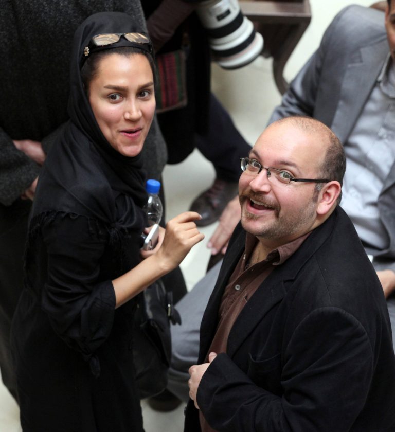 In this photo taken on April 11, 2013, Jason Rezaian, right, an Iranian-American correspondent for the Washington Post, and his wife Yeganeh Salehi, an Iranian correspondent for the Abu Dhabi-based daily newspaper The National, smile as they attend a presidential campaign of President Hassan Rouhani in Tehran, Iran. They have been held in custody for a month since their detention July 2014 in Iran, suggesting a possible struggle between a new guard of moderates pushing for greater freedom and the old hard-line establishment. (AP Photo/Vahid Salemi)