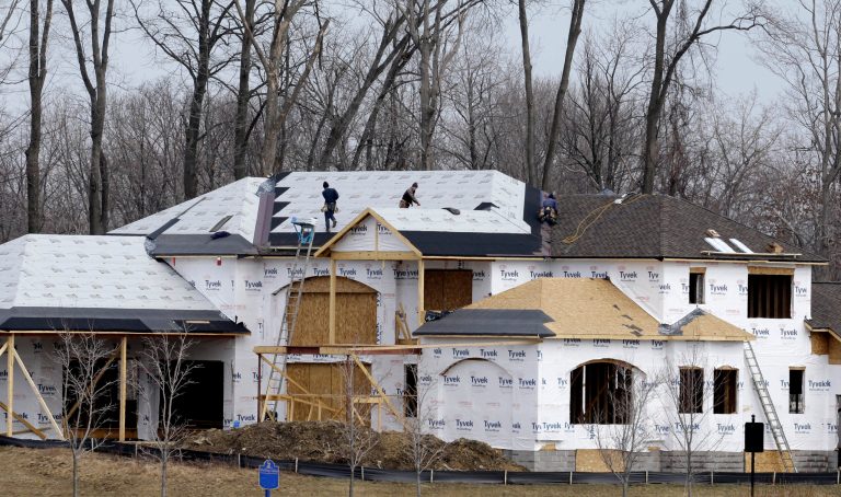 This Friday, March 21, 2014 photo shows roofers installing a roof on a new construction home in Pepper Pike, Ohio. The Commerce Department reports on U.S. home construction in March later Wednesday April 16, 2014. (AP Photo/Tony Dejak)