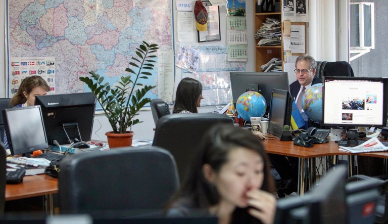 Kyiv Post chief editor Brian Bonner, right, and other journalists work at their desks in Ukraine. Bonner and several other members of his newsroom staff were targeted by the group widely known as Fancy Bear. (AP Photo/Volodymyr Petrov)