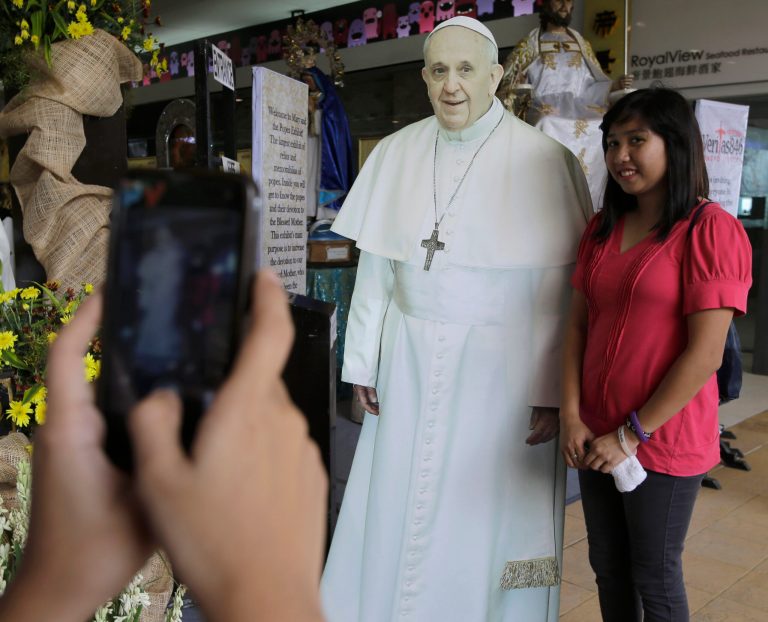 Filipinos have their photos taken with a cutout of Pope Francis at Mall of Asia, the country's largest shopping mall, Wednesday, Sept. 10, 2014 at suburban Pasay city, south of Manila, Philippines. In Asia's bastion of Roman Catholic faith, images of Pope Francis are getting the K-pop treatment. Life-size cardboard cutouts are being distributed to churches, schools and malls in the Philippine capital to generate 
