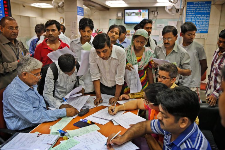 Indians gather around a table inside a state-owned bank to open their accounts as part of a massive countrywide campaign to open millions of accounts for the poor in New Delhi, India, Thursday, Aug. 28, 2014.The measure is aimed at some 150 million Indians who are off the financial grid and vulnerable to black market money lenders. As an incentive the federal government is providing 100,000 rupees ($1,650) in life insurance to every account holder. (AP Photo /Manish Swarup)