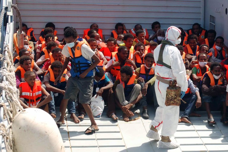 In this Picture released by the Italian Navy, Monday, Aug. 25, 2014, migrants wait to be boarded on the San Giusto Navy ship, along the Mediterranean sea, off the Sicilian island of Lampedusa, Saturday, Aug. 23, 2014. Italian Interior Minister Angelino Alfano renewed his demand for the European Union to relieve pressure on Italy, which has seen some 100,000 migrants arrive so far this year alone. The country says it spends 9.5 million euros ($13 million) a month to operate the beefed-up air and sea patrols that were launched after more than 360 migrants drowned off the Italian island of Lampedusa last October. 