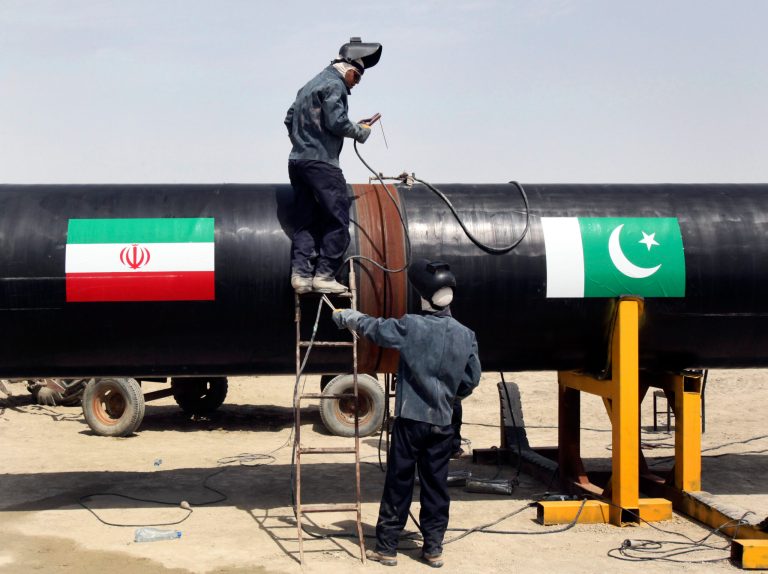 Iranian workers weld two gas pipes together at the start of construction on a pipeline to transfer natural gas from Iran to Pakistan, in Chabahar, southeastern Iran, near the Pakistani border, Monday, March 11, 2013. The leaders of Pakistan and Iran on Monday pushed ahead with a pipeline to bring natural gas from Iran despite American opposition, with the Iranian president saying the West has no right to block the project. Flags of Iran, left, and Pakistan, right, are displayed on the pipes. (AP Photo/Vahid Salemi)