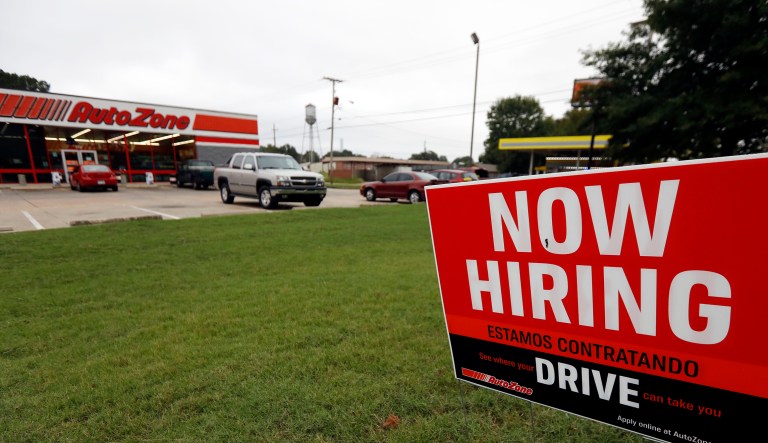FILE- In this Sept. 27, 2018, file photo a bilingual help wanted sign for Auto Zone is posted outside the store in Canton, Miss.