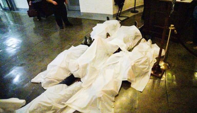 Dozens of demonstrators laid down in from the of the subway entrance as others covered themselves with white sheets to symbolize what they view as the many lives that would be lost under the GOP's healthcare plan. (Photo courtesy: Megaphone Strategies)