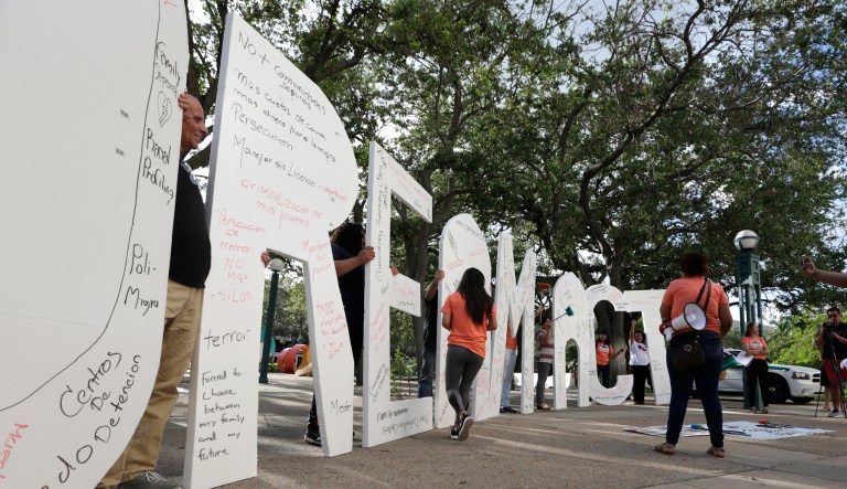 Immigrant rights supporters hold giant letters reading 