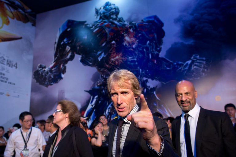 In this Monday June 23, 2014 photo, director Michael Bay, center, gestures to fans as he attends the premiere of movie 