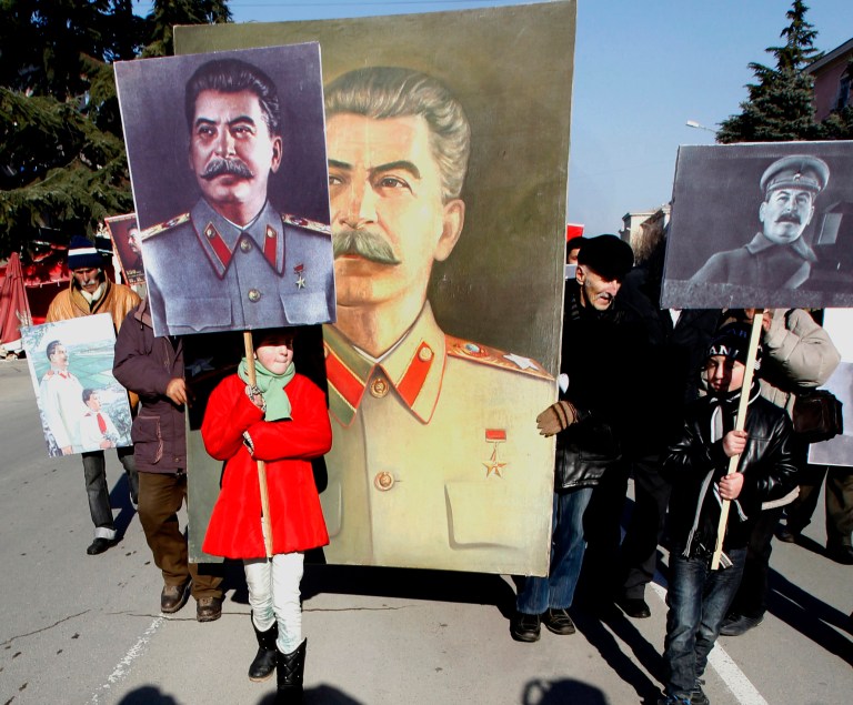 Georgians carry portraits of Soviet dictator Joseph Stalin during a rally marking Stalin's 134th birthday anniversary, in his home town of Gori, 80 kms (50 miles) west of capital Tbilisi, Gergia, Saturday, Dec. 21, 2013. (AP Photo/Shakh Aivazov)