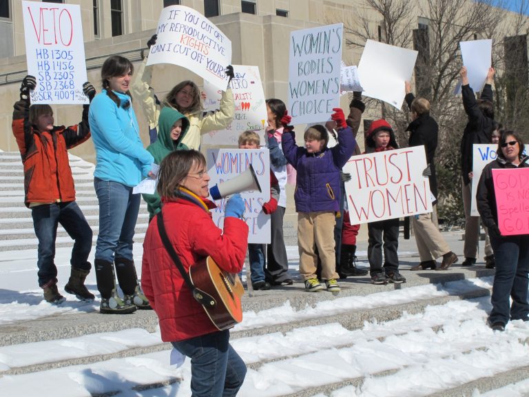 FILE - In this March 25, 2013 file photo, Kris Kitko leads chants of protest at an abortion-rights rally at the state Capitol in Bismarck, N.D. Rival legal teams, each well-financed and highly motivated, are girding for high-stakes court battles over the coming months on laws enacted in Arkansas and North Dakota that would impose the nation's toughest bans on abortion. The Arkansas law, approved March 6 when legislators overrode a veto by Democratic Gov. Mike Beebe, would ban most abortions from the 12th week of pregnancy onward. On March 26, North Dakota went even further, with Republican Gov. Jack Dalrymple signing a measure that would ban abortions as early as six weeks into a pregnancy, when a fetal heartbeat can first be detected. (AP Photo/James MacPherson, File)