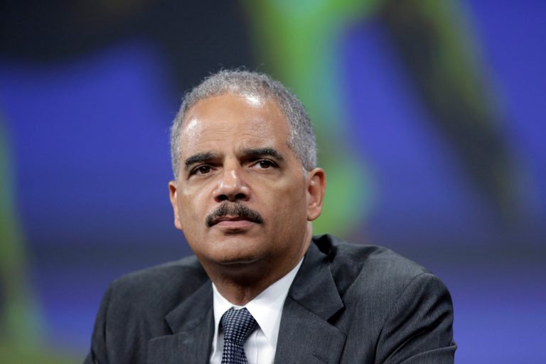 FILE - In this Oct. 21, 2013 file photo, Attorney General Eric Holder listens to a speech after of his remarks during the Annual International Association of Chiefs of Police Conference, at the Pennsylvania Convention Center in Philadelphia.  The FBI has helped to disrupt or prevent nearly 150 shootings and violent attacks in 2013 alone, in part by steering potential gunmen toward mental health professionals. There have been hundreds of these disruptions since 2011, Attorney General Eric Holder told an audience of police chiefs in October, touting the behind-the-scenes work of a small FBI unit based out of Quantico, Va. (AP Photo/Matt Rourke)