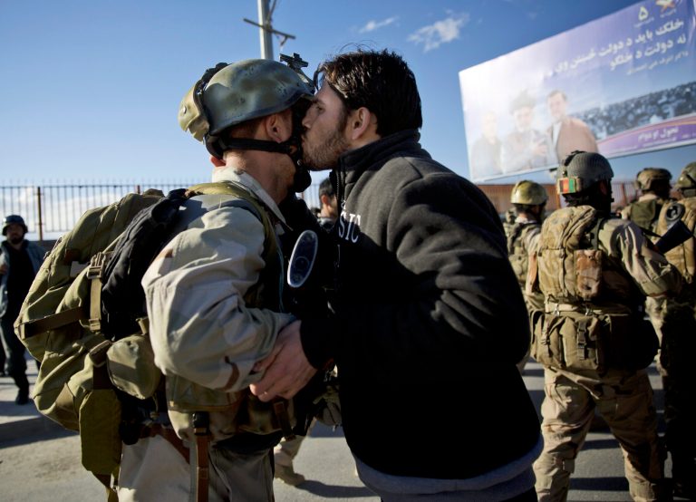 An Afghan special forces soldier, left, is kissed by an Afghan man after the commandos took over control of an election office after the Taliban launched an assault with a suicide bomber detonating his vehicle outside an election office on the edge of Kabul, Afghanistan, Tuesday, March 25, 2014. Gunmen stormed into the building, trapping dozens of employees inside and killing four people. A candidate for a seat on a provincial council was among those killed, along with an election worker, a civilian and a policeman. (AP Photo/Anja Niedringhaus)