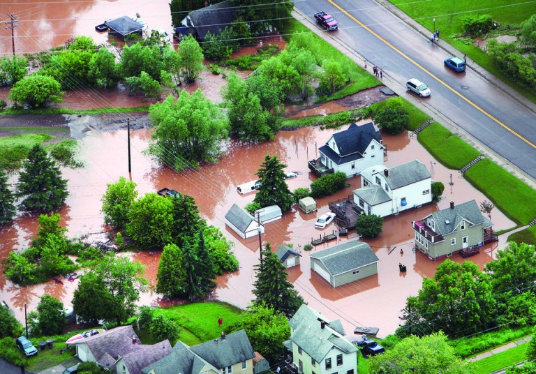 In this aerial photo, waters from an overflowing nearby creek inundate homes in the Irving Park neighborhood of Duluth, Minn., Wednesday afternoon, June 20, 2012. Residents evacuated their homes and animals escaped from pens at a zoo as floods fed by a steady torrential downpour struck northeastern Minnesota, inundating the city of Duluth, officials said Wednesday. (AP Photo/The Duluth News-Tribune, Bob King)