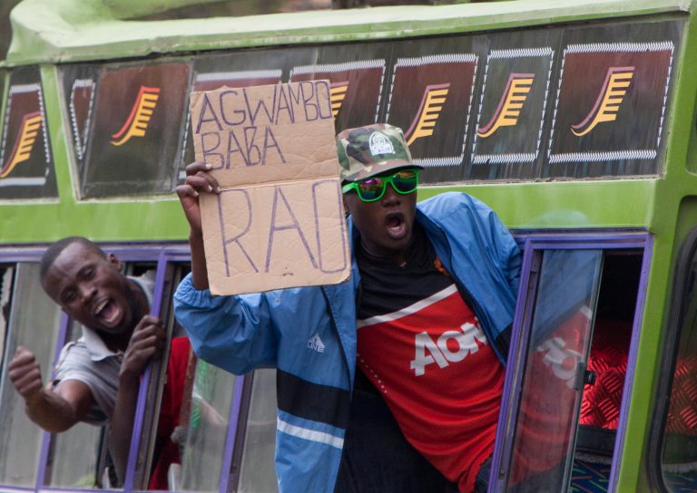 A  supporters of  the  opposition Coalition for Reforms and Democracy or Cord  holds a placard in a bus  reading in Leo language 
