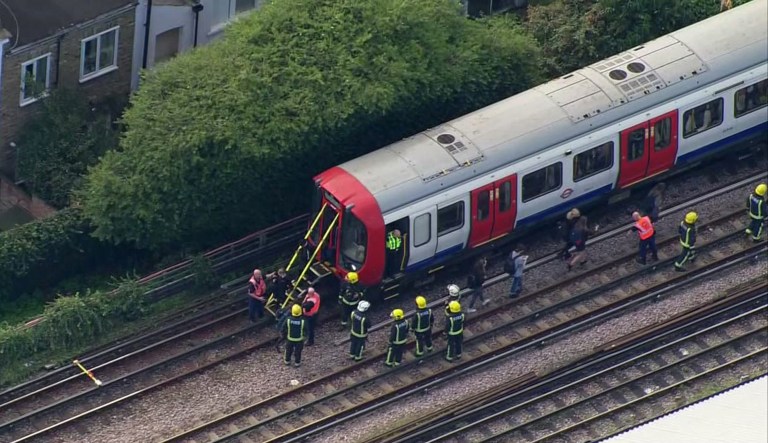 Emergency workers help people to disembark a train near the Parsons Green Underground Station after an explosion in London. 15, 2017. The police said they were investigating it as a terrorist attack. (Pool via AP)