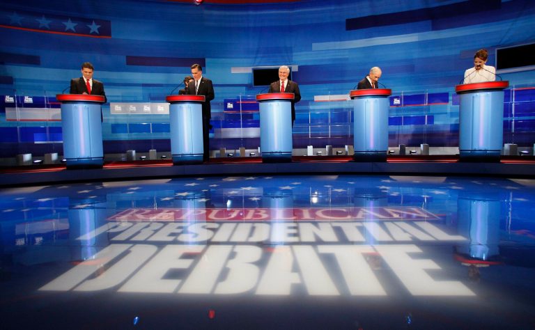 Republican presidential candidates from left, Texas Gov. Rick Perry, former Massachusetts Gov. Mitt Romney, former House Speaker Newt Gingrich, Rep. Ron Paul, R-Texas, Rep. Michele Bachmann, R-Minn., prepare for a Republican presidential debate in Sioux City, Iowa, Thursday, Dec. 15, 2011. (AP Photo/Eric Gay)