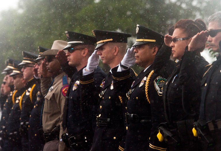 Police officers and sheriff's deputies from multiple departments throughout Central Texas salute during the funeral services for Little River-Academy Police Chief Lee Dixon on Thursday, June 26, 2014, in Temple, Texas. Dixon was shot and killed on June 19 as he was responding to a call about a man with a gun. David Gene Risner, a former law enforcement officer, has been charged with capital murder in the case. (AP Photo/The Temple Daily Telegram, Josh Quinn)