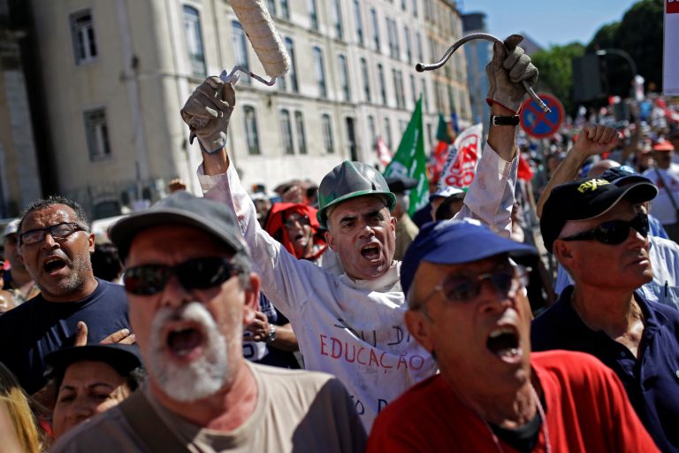 People shout slogans outside the Portuguese parliament during a protest by Portugal's main union CGTP, General Confederation of the Portuguese Workers, against cuts in salaries and pensions and others austerity measures taken by the government, in Lisbon, Thursday, July 10, 2014. (AP Photo/Francisco Seco)