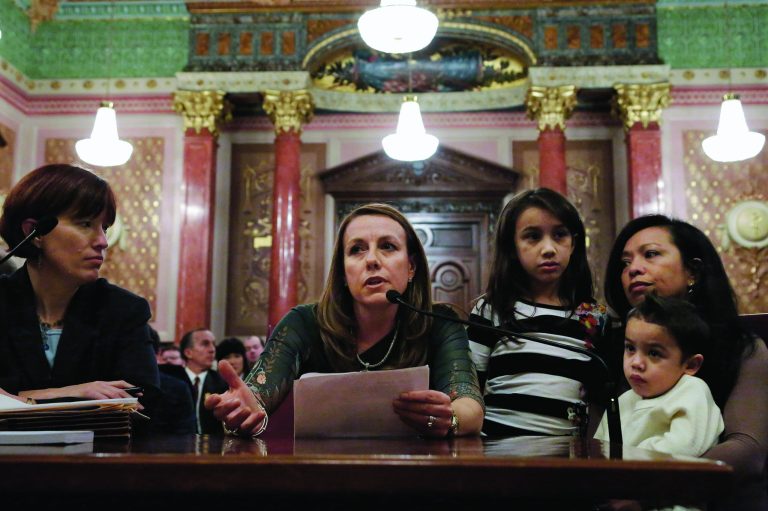 In this Jan. 3, 2013 photo, Theresa Volpe, second from left, testifies alongside her daughter Ava as her partner Mercedes Santos, right, sits with their son Jaidon during a Senate Executive committee hearing considering same sex marriage at the Illinois State Capitol in Springfield, Ill. Despite a nudge from the home-state president, soaring support in the polls and national momentum from the November elections, the stalling of the gay marriage push in Illinois shows how tricky it is to get a legislature to approve same-sex unions. Illinois Sen. Heather Steans, D-Chicago, a supporter for same sex marriage, left, looks on. (AP Photo/Seth Perlman)