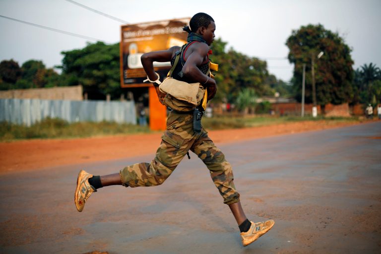 An anti-Balaka Christian militiaman runs across a major avenue heading to the predominantly Muslim Miskin neighborhood downtown Bangui, Central African Republic, Friday Jan. 24, 2014. Moments later, heavy gunfire erupted between anti-Balakas and Seleka Muslim militias, prompting the intervention of Rwandan and French forces who also used fire power. (AP Photo/Jerome Delay)