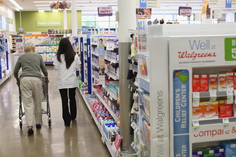 Pharmacist Jeanie Kim (R) helps a customer at a Walgreens pharmacy on September 19, 2013 in Wheeling, Illinois. (Photo by Scott Olson/Getty Images)