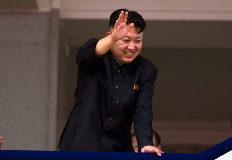FILE - In this July 27, 2013 file photo, North Korean leader Kim Jong Un leans over a balcony and waves to Korean War veterans cheering below at the end of a mass military parade on Kim Il Sung Square in Pyongyang to mark the 60th anniversary of the Korean War armistice. North Korea is warning that the release of a new American comedy about a plot to assassinate leader Kim Jong Un would be an 