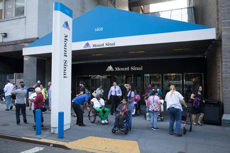 Pedestrians stand outside Mount Sinai Medical Center where a male patient with a high fever and gastrointestinal symptoms is undergoing testing for the Ebola virus  following a recent trip to West Africa, Monday, Aug. 4, 2014, in New York. The report comes as officials at U.S. airports are watching travelers from Africa for flu-like symptoms that could be tied to the recent Ebola outbreak. (AP Photo/John Minchillo)