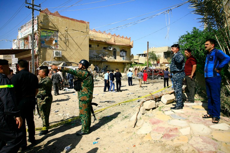 Security forces and civilians gather at the site of a car bomb attack in Hillah, about 60 miles (95 kilometers) south of Baghdad, Iraq, Thursday, April 3, 2014. A car bomb exploded Thursday near the house of Ali al-Maliki, a Shiite candidate running in the upcoming election. The explosion killed a civilian passer-by and wounded several. Police said that neither al-Maliki nor any family members were hurt in the attacks. Al-Maliki is running in the bloc headed by Iraqi Prime Minister Nouri al-Maliki.(AP Photo)
