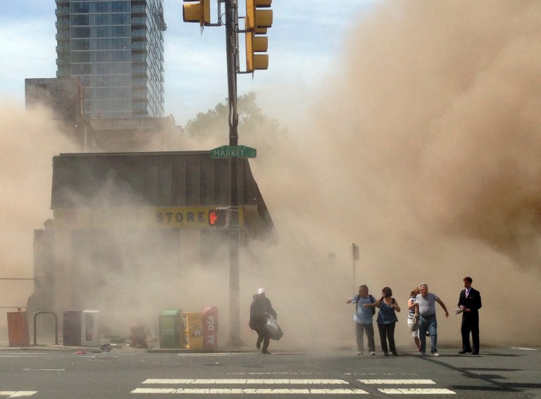 FILE - In this file photo provided by Jordan McLaughlin, a dust cloud rises as people run from the scene of a building collapse on the edge of downtown Philadelphia on Wednesday, June 5, 2013. An official says an inspector who surveyed a Philadelphia building before it collapsed last week, killing six people, has committed suicide. Deputy Mayor Everett Gillison says the inspector was found fatally shot in a pickup truck Wednesday night, June 12, 2013. The man was a Department of Licenses and Inspections employee who had inspected the building May 14. (AP Photo/Jordan McLaughlin, File)