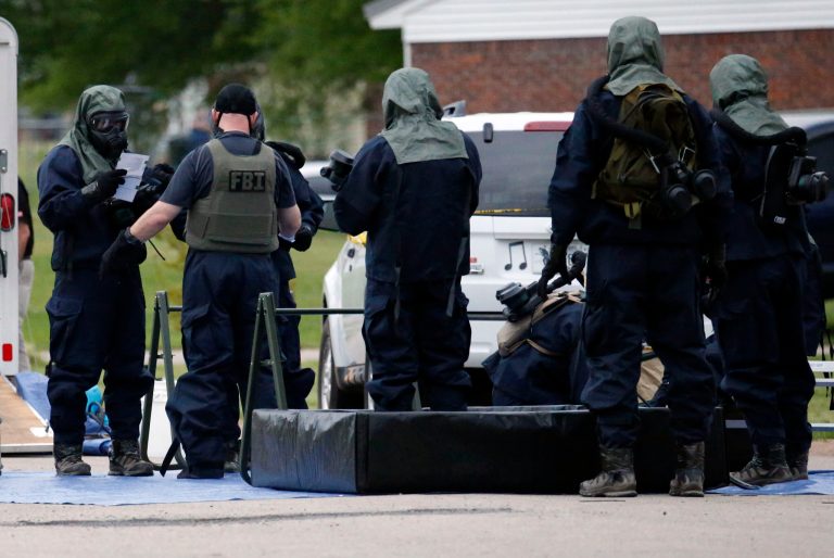 Armed federal agents wearing hazardous material suits and breathing apparatus begin personal cleanup after entering the West Hills Subdivision home of Paul Kevin Curtis in Corinth, Miss., Thursday evening April 18, 2013. All suits and gear, including weapons were placed in hazardous materials bags for extensive cleanup. Law enforcement officials blocked off the dwelling after taking Curtis into custody under the suspicion of sending letters covered in ricin to the U.S. President Barack Obama and U.S. Sen. Roger Wicker, R-Miss. (AP Photo/Rogelio V. Solis)