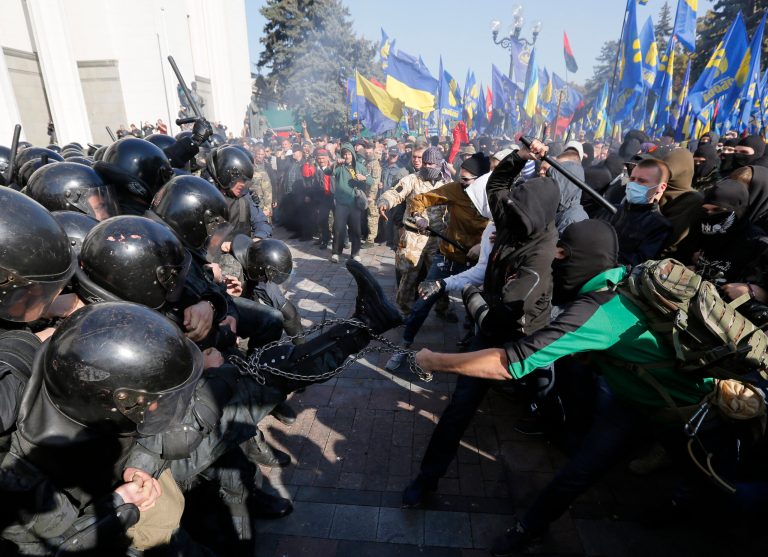 Police clash with  demonstrators outside parliament in Kiev, Ukraine, on Tuesday, Oct. 14, 2014, as deputies repeatedly voted down proposals to officially recognize a contentious WWII-era partisan group as national heroes. Thousands of Svoboda nationalist party supporters rallied in Kiev earlier in the day in celebration of the Ukrainian Insurgent Army, but officials from the party denied vehemently that its members were involved in the unrest.(AP Photo/Sergei Chuzavkov)