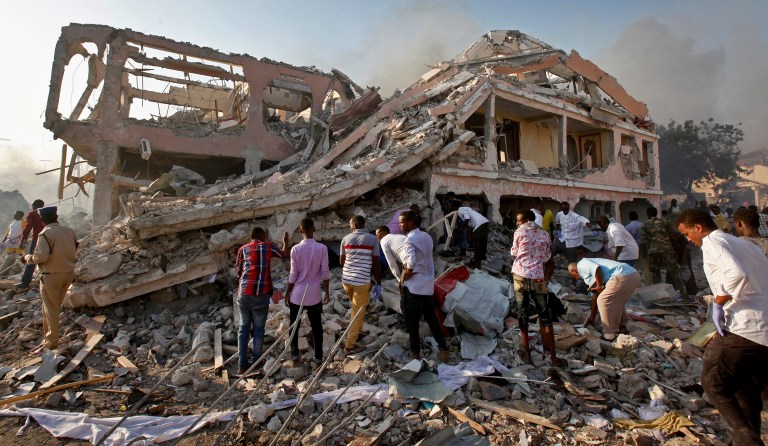 Somalis gather and search for survivors by destroyed buildings at the scene of a blast in the capital Mogadishu, Somalia, Saturday, Oct. 14, 2017.(AP Photo/Farah Abdi Warsameh)