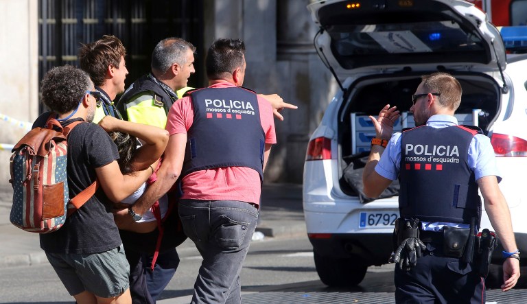 An injured person is carried in Barcelona, Spain, Thursday, Aug. 17, 2017, after a white van jumped the sidewalk in the historic Las Ramblas district, crashing into a summer crowd of residents and tourists and injuring several people, police said. (AP Photo/Oriol Duran)