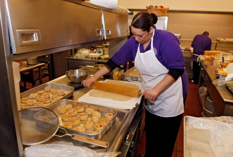 FILE - In this Jan. 18, 2012, file photo, Alexes Garcia makes cinnamon rolls for student's lunch in the kitchen at Kepner Middle School in Denver. The rolls are made using apple sauce instead of trans fats. Heart-clogging trans fats have been slowly disappearing from grocery aisles and restaurant menus in the last decade as nutritionists have criticized them and local governments have banned them. The Food and Drug Administration is now finishing the job as they announce Nov. 7, 2013, that it will require the food industry to gradually phase out trans fats, saying they are a threat to the health of Americans.(AP Photo/Ed Andrieski, File)