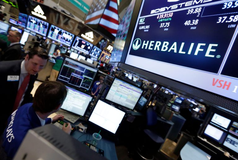A pair of specialists confer at the post that handles Herbalife on the floor of the New York Stock Exchange Thursday, Feb. 28, 2013. (AP Photo/Richard Drew)