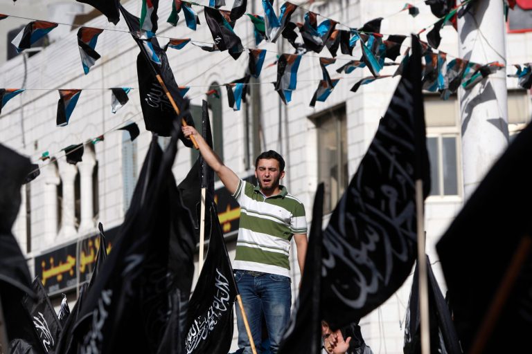 Palestinian supporters of Hizbut-Tahrir, or Party of Liberation, shout slogans during a rally in the West Bank city of Ramallah, Tuesday , June 4, 2013. Arabic words on the flags read: 