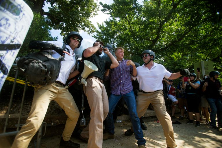 Protesters stands in front of state troopers in attempt to block them in during a white nationalist rally on Saturday Aug. 12, 2017, in Charlottesville, Va. The nationalists had gathered to protest plans by the city of Charlottesville to remove a statue of Confederate Gen. Robert E. Lee. (Shaban Athuman /Richmond Times-Dispatch via AP)