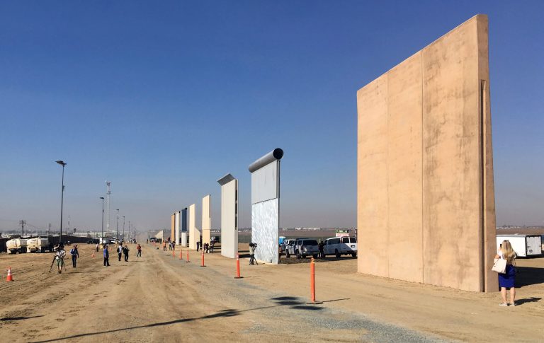 People look at prototypes of a border wall Thursday, Oct. 26, 2017, in San Diego. 