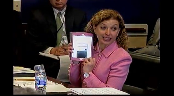 Rep. Debbie Wasserman Schultz showing a House bathroom feminine hygiene dispenser that is out of order.