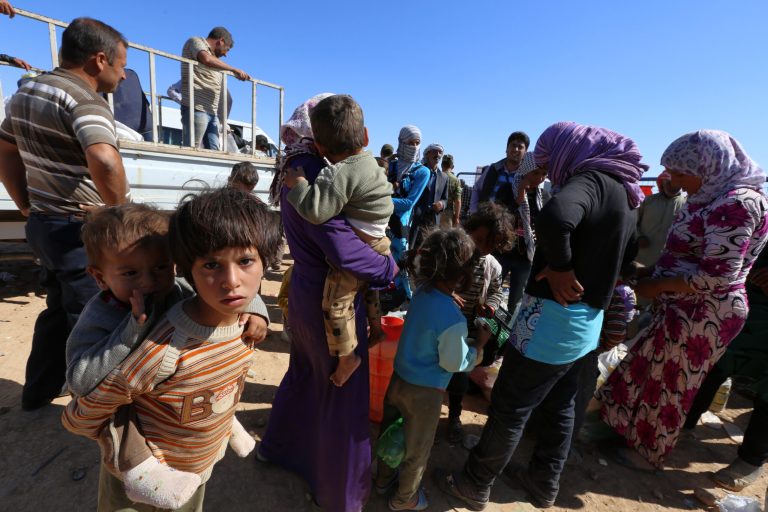 Syrian Kurdish wait for transport as thousands of new Syrian refugees from Kobani arrive at the Turkey-Syria border  crossing of Yumurtalik near Suruc, Turkey, Wednesday, Oct. 1, 2014. U.S.-led coalition airstrikes targeted Islamic State fighters pressing their offensive against a Kurdish town near the Syrian-Turkish border on Tuesday in an attempt to halt the militants' advance, activists said.(AP Photo/Burhan Ozbilici)
