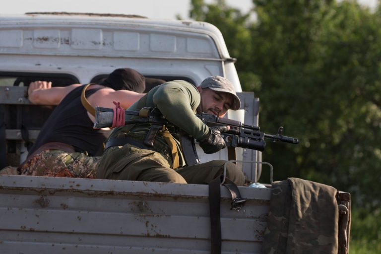 Pro-Russian men hold their weapons atop a vehicle as they arrive to support their comrades at a checkpoint outside Slovyansk, eastern Ukraine, Thursday, May 15, 2014. On Thursday, Ukraine's acting president, Oleksandr Turchynov, claimed the Ukrainian army destroyed an insurgent base in the city of Slovyansk and another one in nearby Kramatorsk, about 150 kilometers (95 miles) west of the Russian border. (AP Photo/Alexander Zemlianichenko)