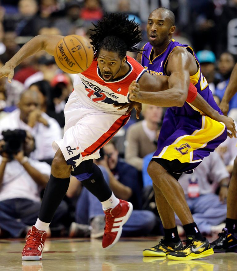   Washington Wizards center Nene, from Brazil, and Los Angeles Lakers guard Kobe Bryant go for the loose ball in the first half of an NBA basketball game Friday, Dec. 14, 2012 in Washington. (AP Photo/Alex Brandon)  