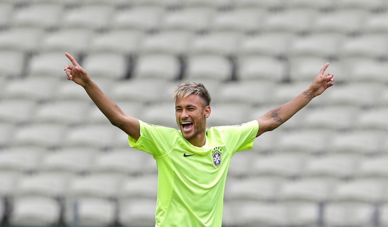 FILE - This June 16, 2014 file photo shows Brazil's Neymar smiling as he holds out his arms during a training session at the Arena Castelao in Fortaleza, Brazil. Through one week of the World Cup, Facebook has already seen more people having more interactions about the tournament on the social media site than it had for the Sochi Olympics, Super Bowl and Academy Awards combined. A photo posted by Pitbull, who performed at the opening ceremonies, has received more than 1.2 million interactions, as has a photo posted by Brazilian soccer star Neymar, Facebook said. (AP Photo/Andre Penner)