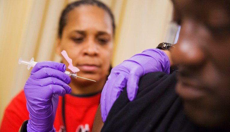 Todd Nelson, right, gets a flu shot from nurse Nicole Simpson at the Salvation Army in Atlanta, Wednesday, Feb. 7, 2018. (AP Photo/David Goldman)