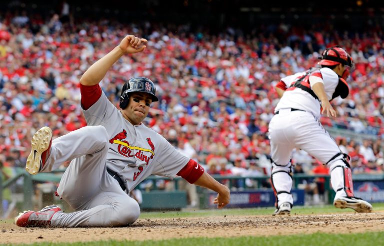 St. Louis Cardinals' Carlos Beltran, left, slides into home plate past Washington Nationals catcher Kurt Suzuki for a run on a single by Matt Holliday in the eighth inning of Game 3 of the National League division baseball series on Wednesday, Oct. 10, 2012, in Washington. (AP Photo/Alex Brandon)